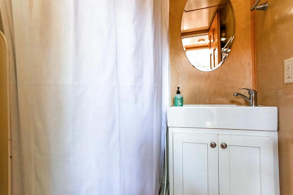 ein Badezimmer mit einem weißen Duschvorhang und einem Waschbecken in der Unterkunft Tiny House in Austin