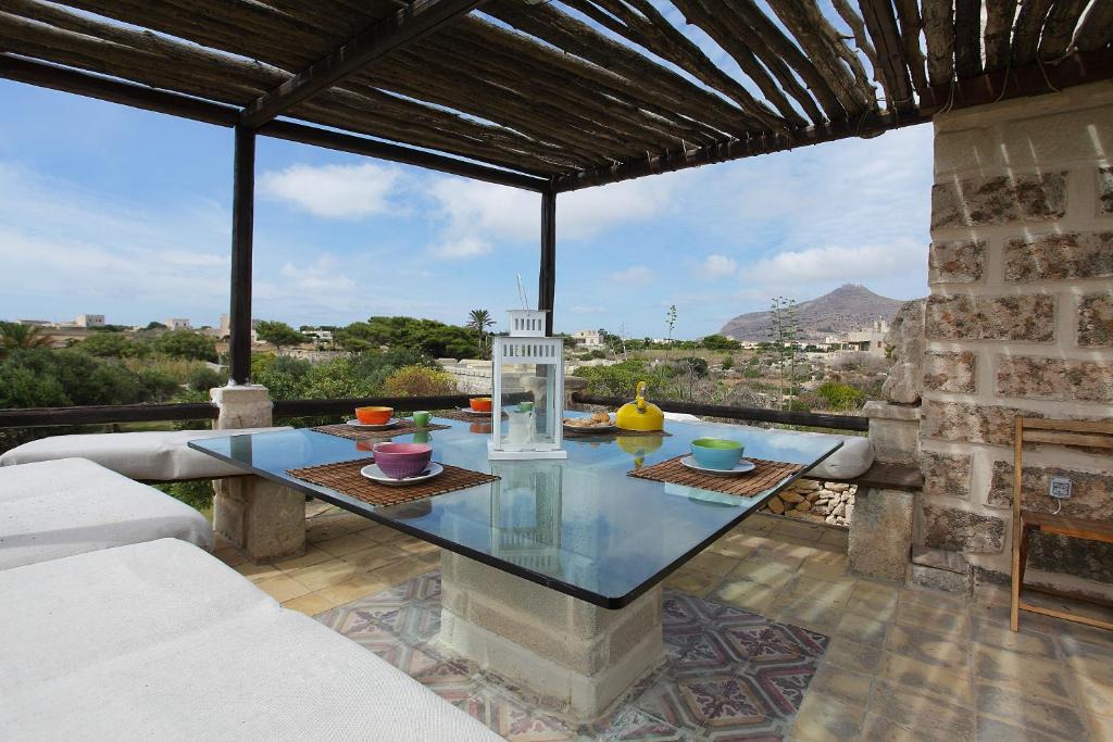 a glass table on a patio with a view at Villa Punta San Nicola in Favignana