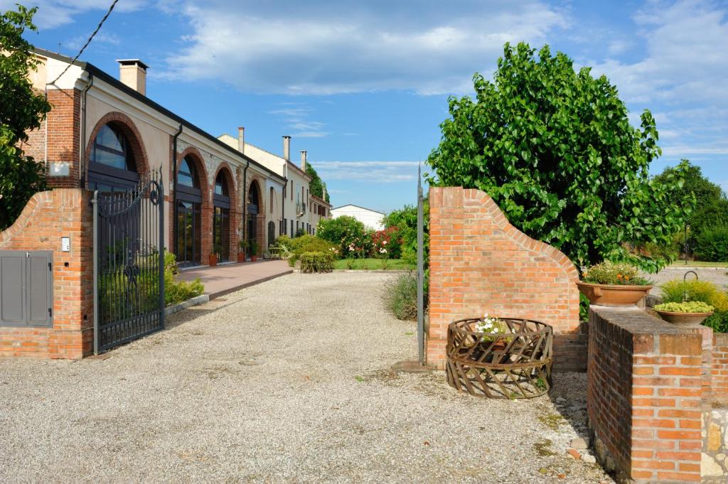 un edificio de ladrillo con una puerta y una valla en Corte delle Giuggiole, en Cologna Veneta