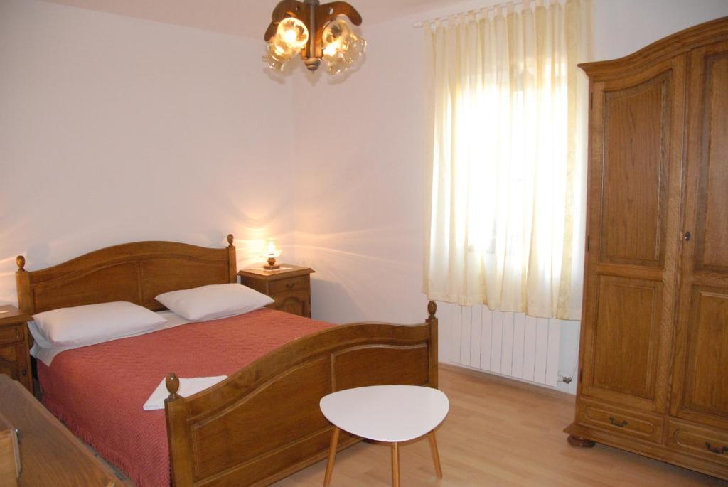 Schlafzimmer mit einem Bett, einem Tisch und einem Fenster in der Unterkunft Rooms Danica in Bale