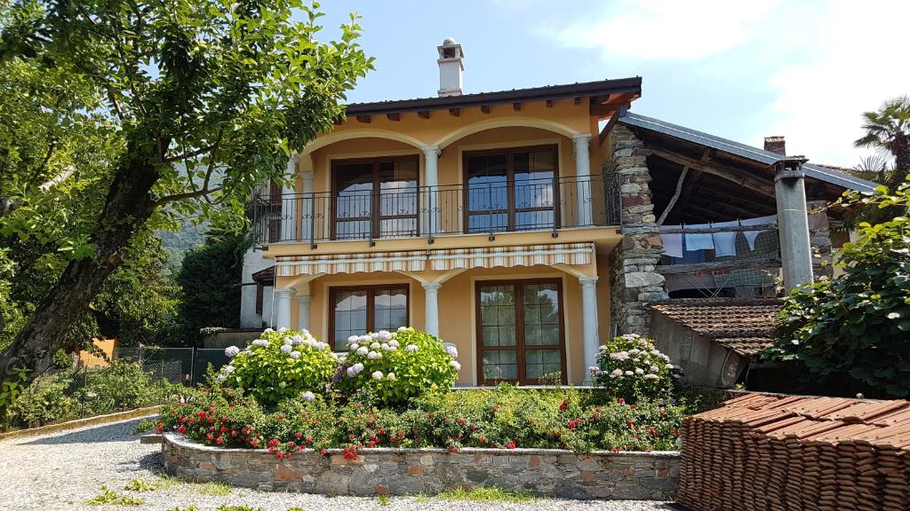 ein gelbes Haus mit Balkon darüber in der Unterkunft La Cascinetta in Porto Valtravaglia