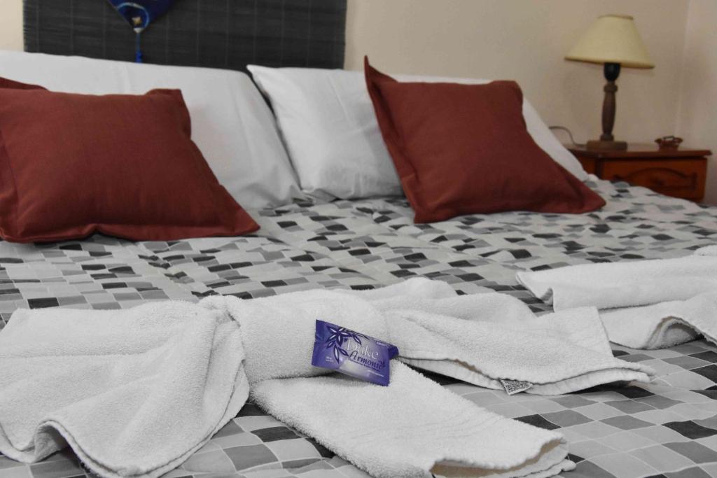 Una cama con toallas y almohadas. en Residencial El Hogar en Salta