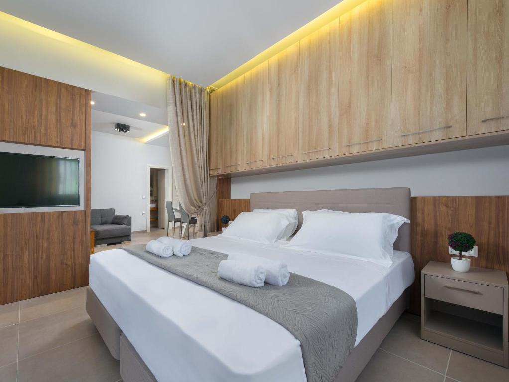 a bedroom with a large white bed with towels on it at Lardos Luxury Apartments in Lardos