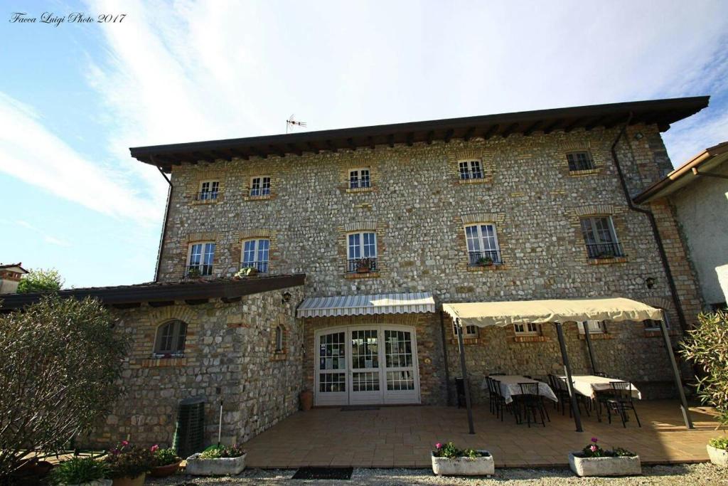 un gran edificio de piedra con mesas y sillas delante de él en Albergo Julienne, en Arba