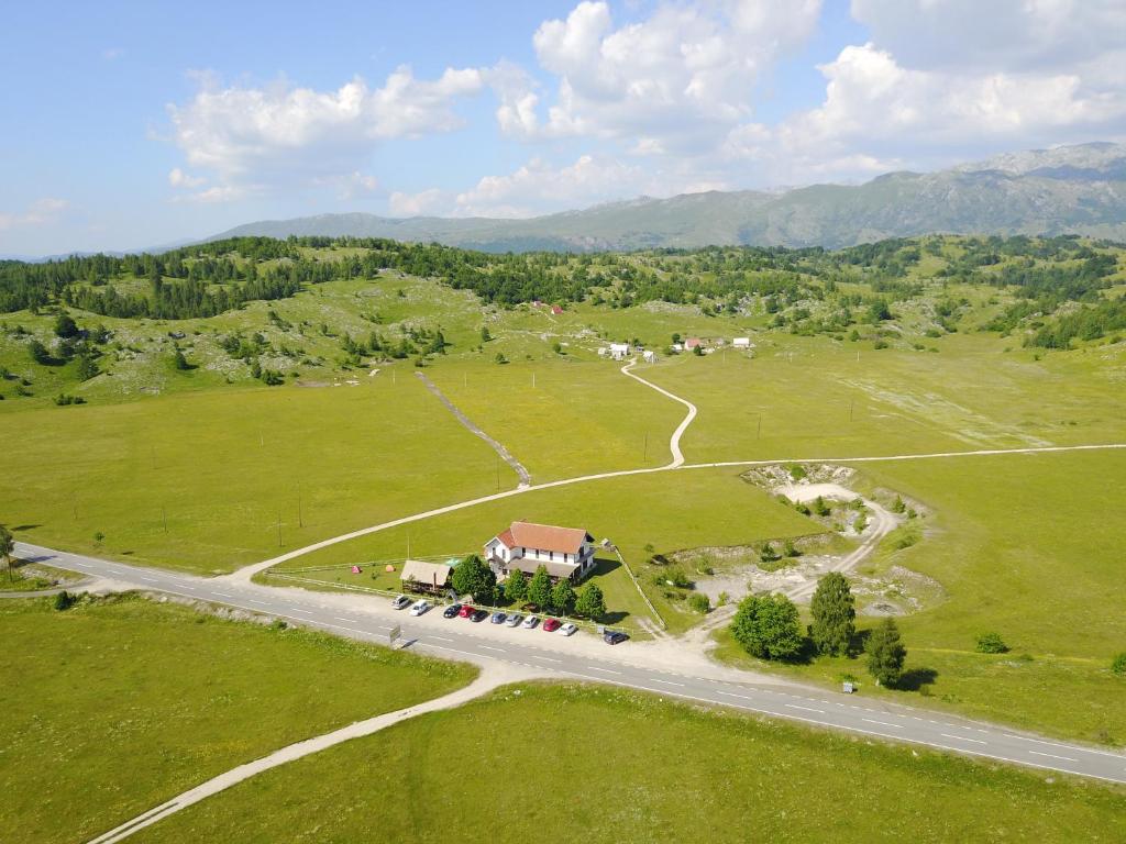 an aerial view of a house in a field with a road at Motel Zaborje in Plužine