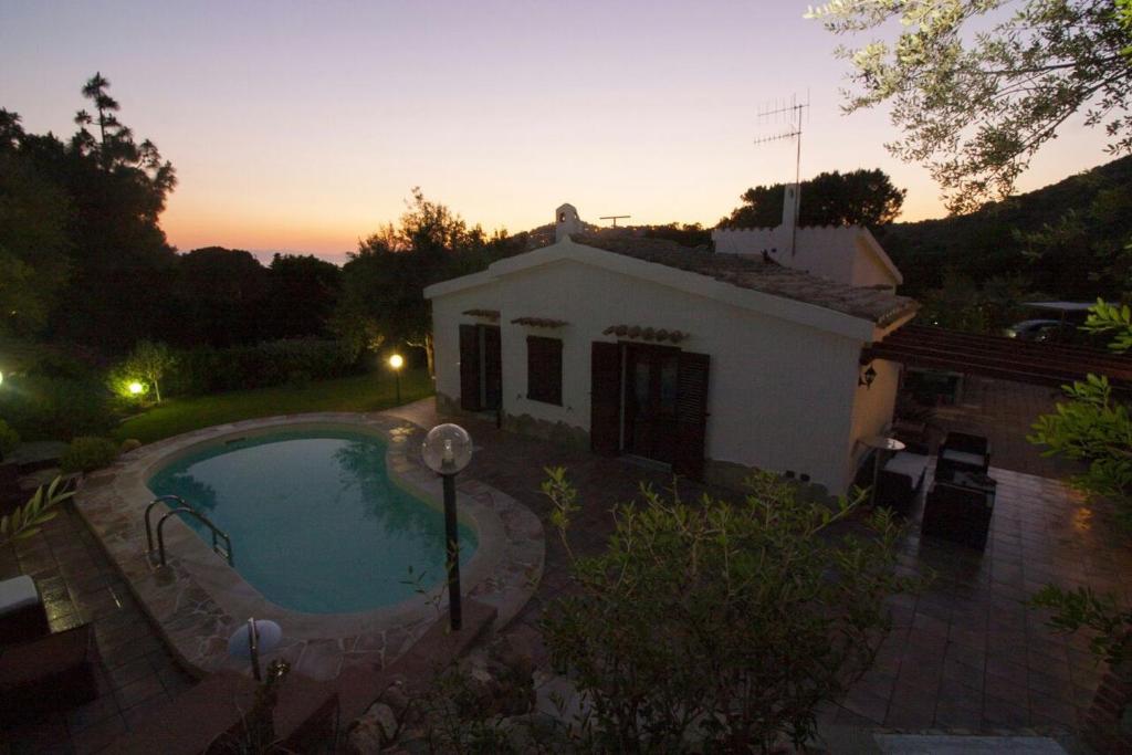 une maison avec une piscine dans la cour dans l'établissement Almà, à Torre delle Stelle