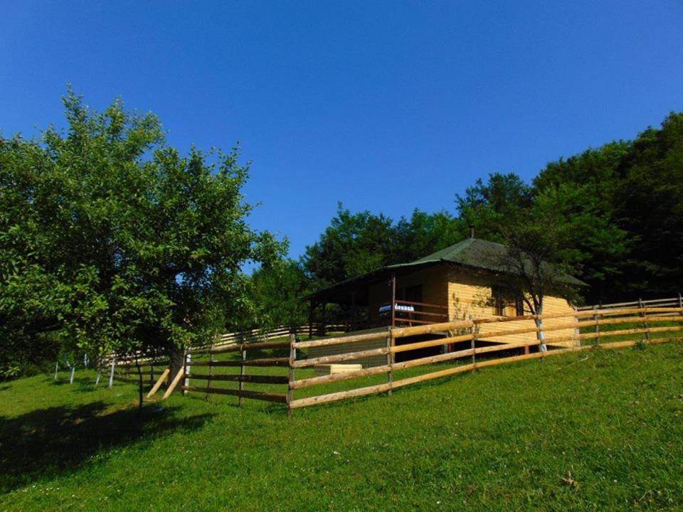 une clôture en bois et un bâtiment dans un champ dans l'établissement Forest Lodge on the Pyramid, à Visoko