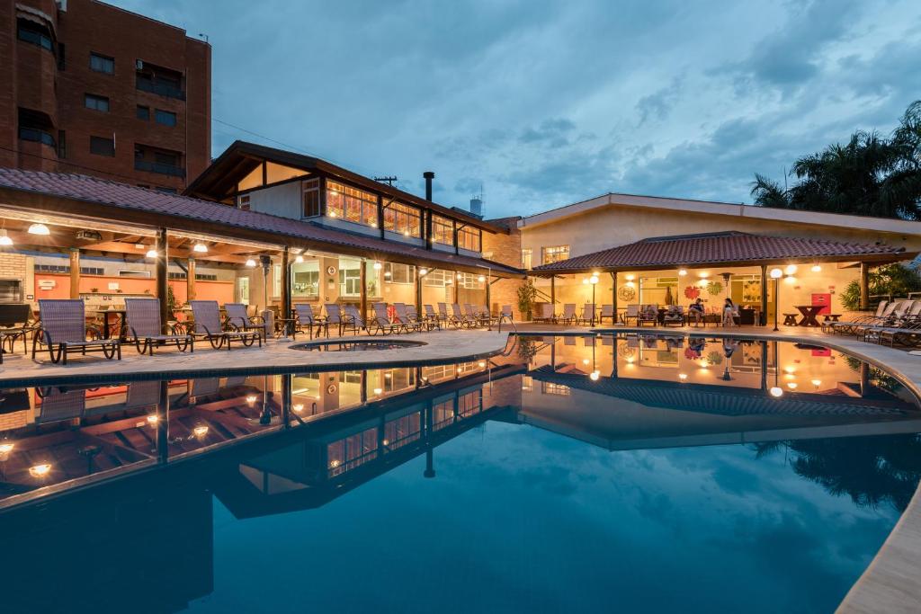 un hotel con piscina frente a un edificio en LS Villas Hotel & Spa en Águas de São Pedro