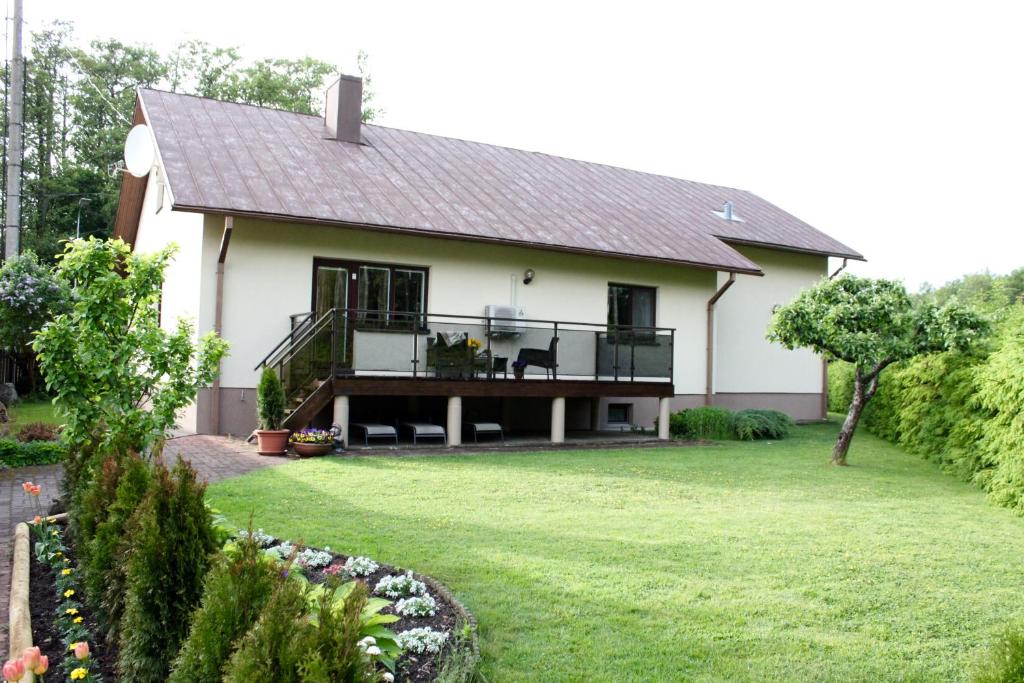 a white house with a balcony and a yard at Tiigi Villa in Haapsalu