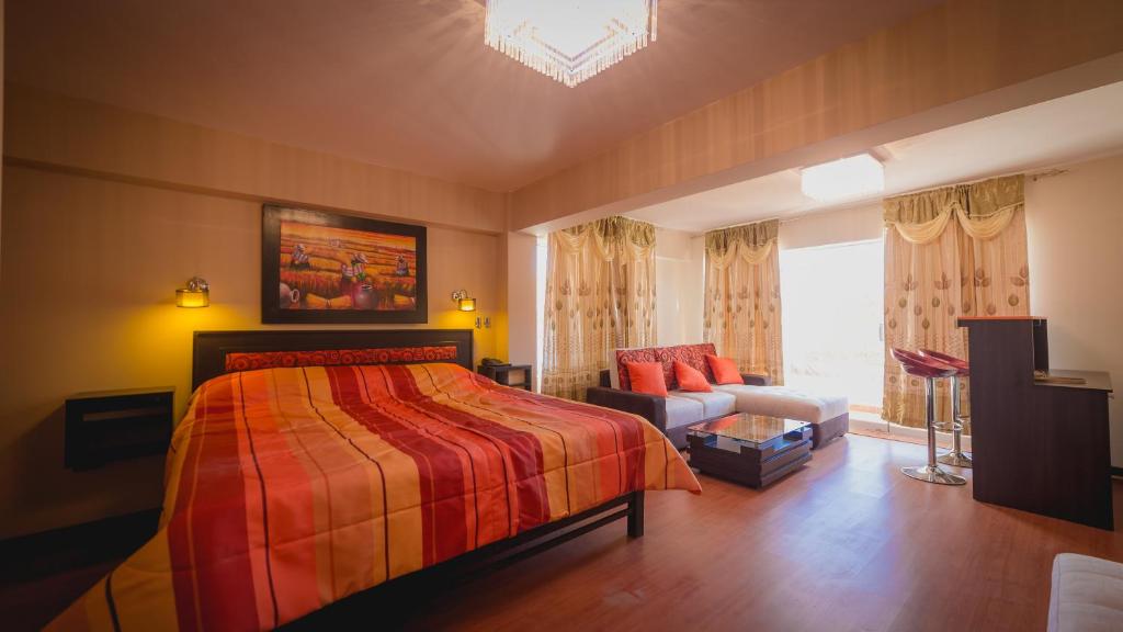 - une chambre avec un lit, un canapé et une fenêtre dans l'établissement Hotel Koricancha, à Sicuani