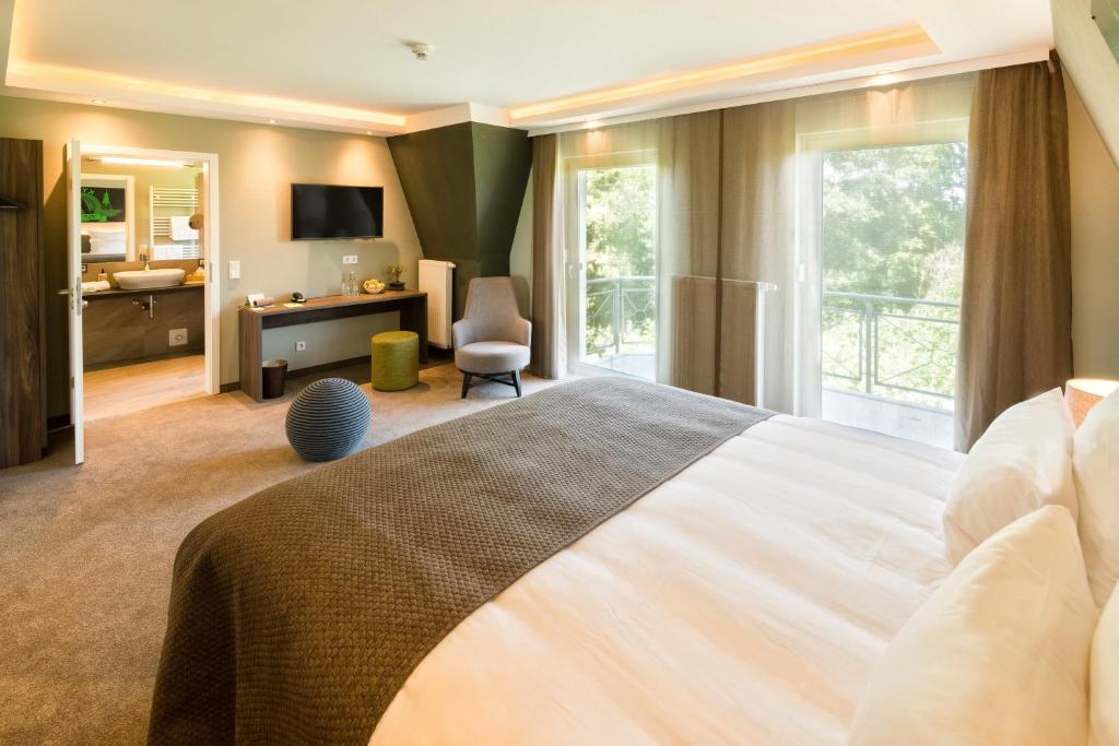 a bedroom with a large bed and a bathroom at Pura Vida Hotel Cuxhaven in Cuxhaven