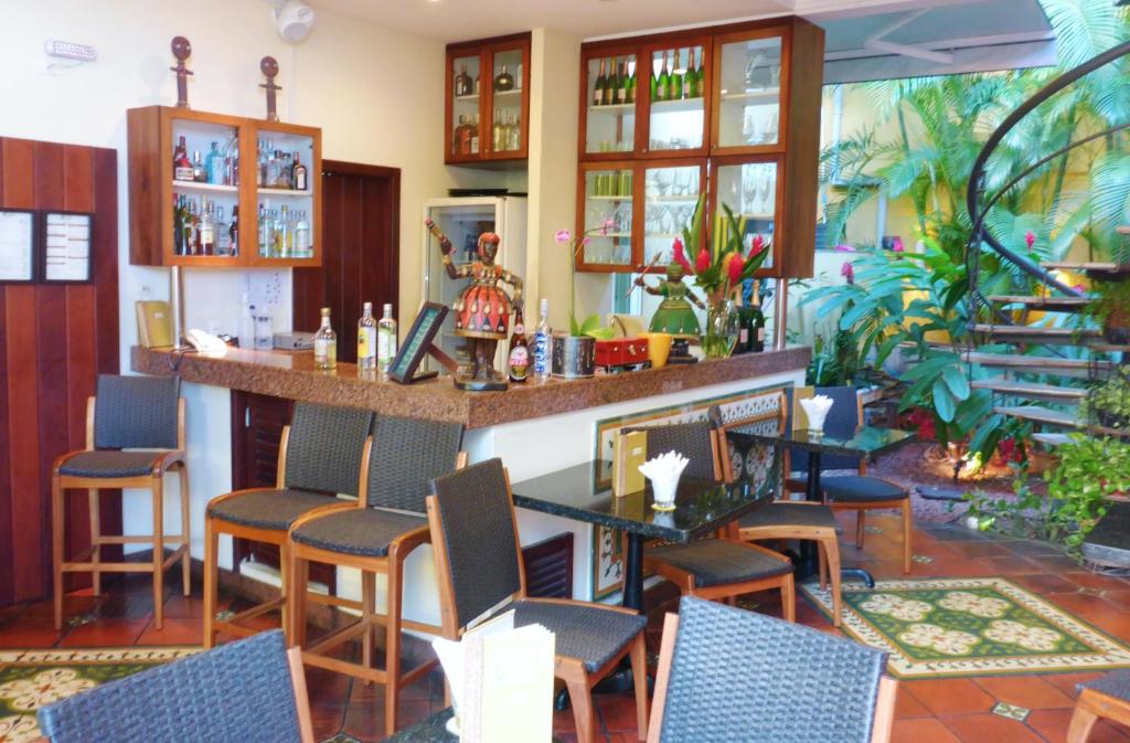 a bar in a restaurant with chairs and a counter at Hotel Casa do Amarelindo in Salvador