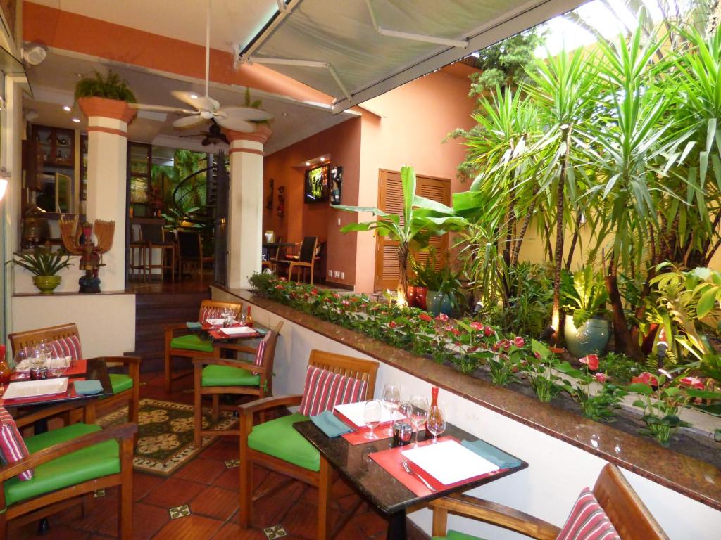 a restaurant with tables and chairs and plants at Hotel Casa do Amarelindo in Salvador