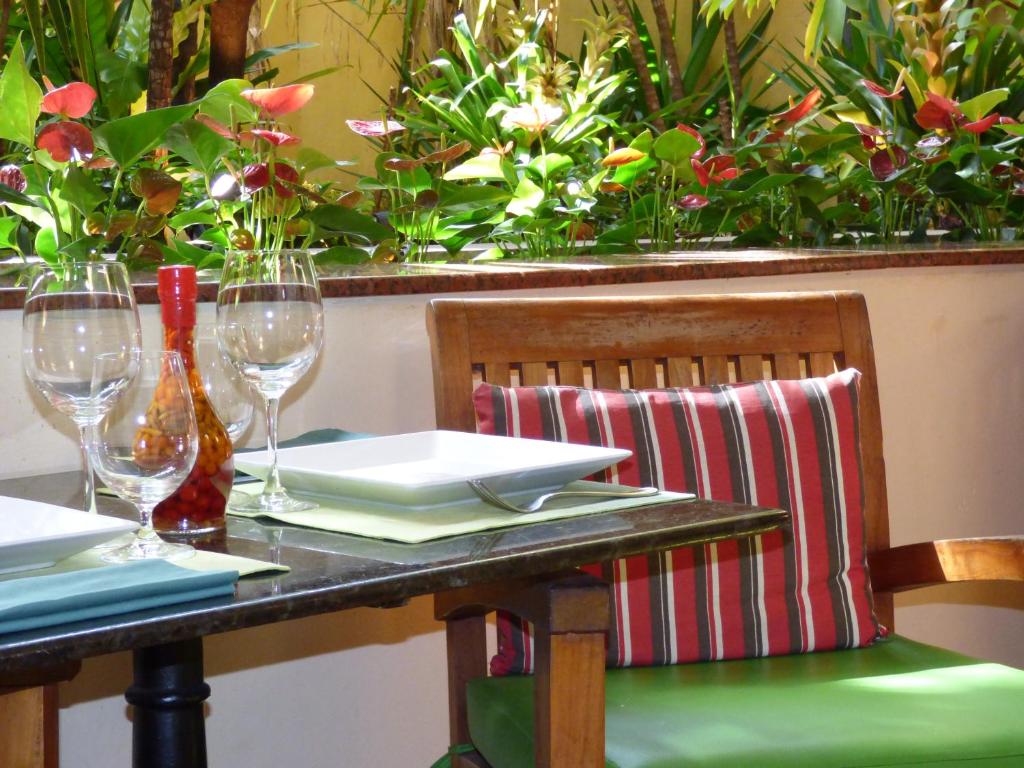a table with wine glasses and a green chair at Hotel Casa do Amarelindo in Salvador