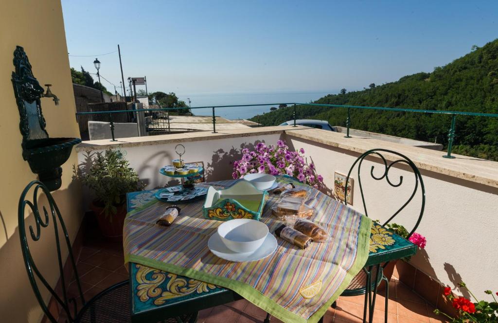 a table with a plate of food on a balcony at Casa Felice in Vietri sul Mare
