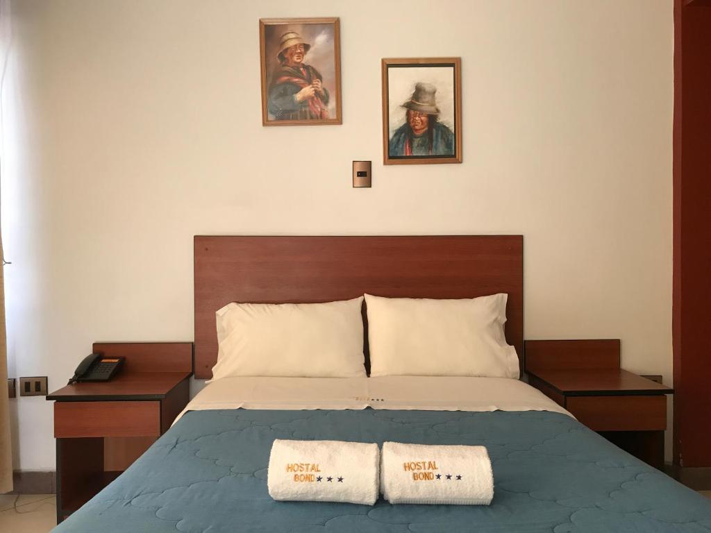1 dormitorio con 1 cama y 2 cuadros en la pared en Hostal Bond, en Huaraz