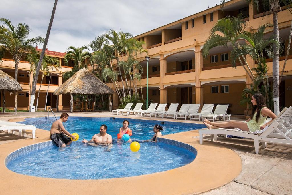 a group of people playing in a swimming pool at Hotel Margaritas in Mazatlán