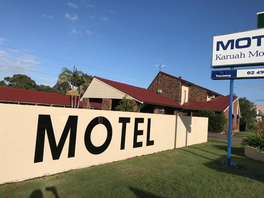 una señal para un motel frente a una casa en Karuah Motor Inn en Karuah