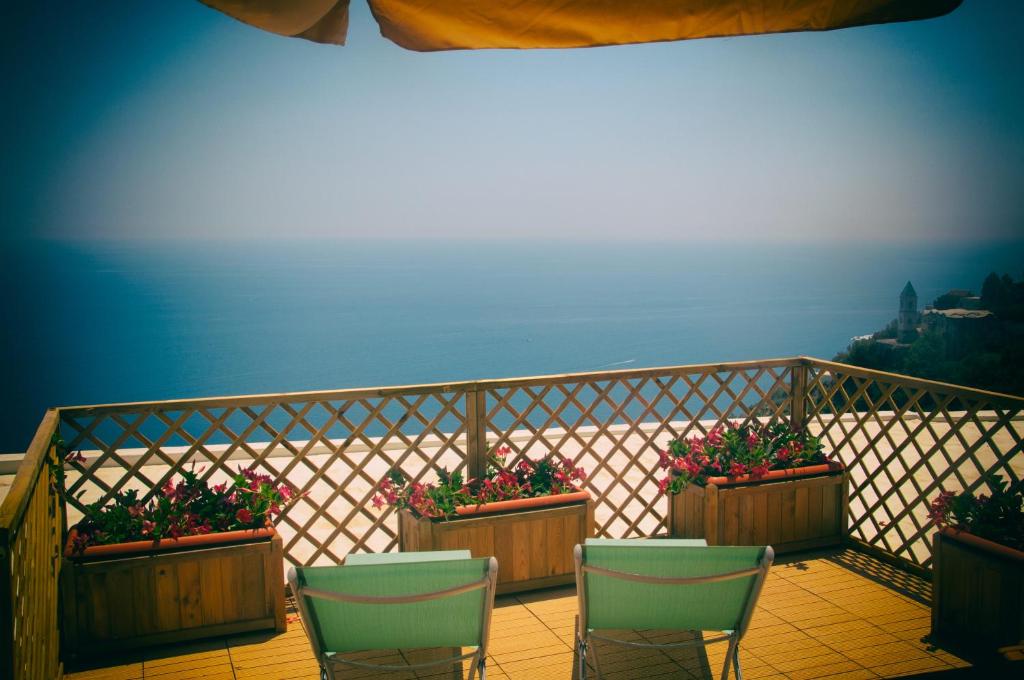a balcony with three chairs and potted plants at Casa Martina in Amalfi