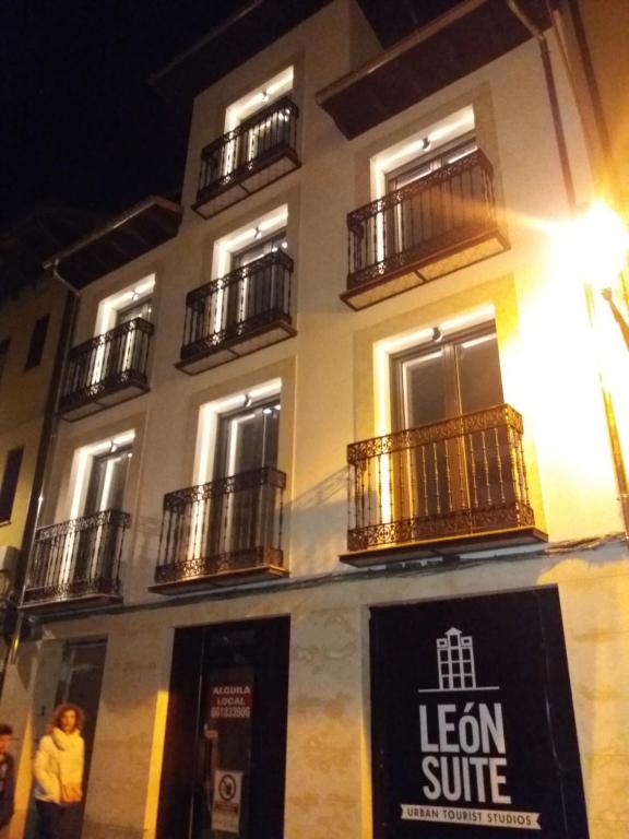 un edificio con balcones y una señal frente a él en LEÓN SUITE Urban Studios, en León