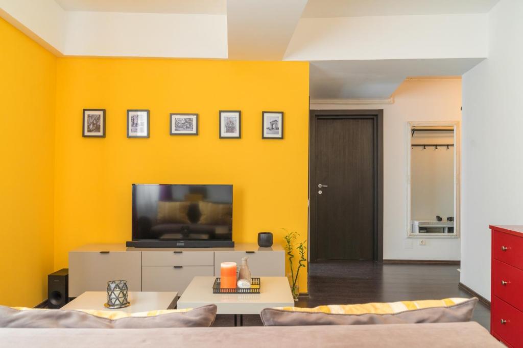 布加勒斯特的住宿－Parlament Fancy Apartments，客厅设有黄色墙