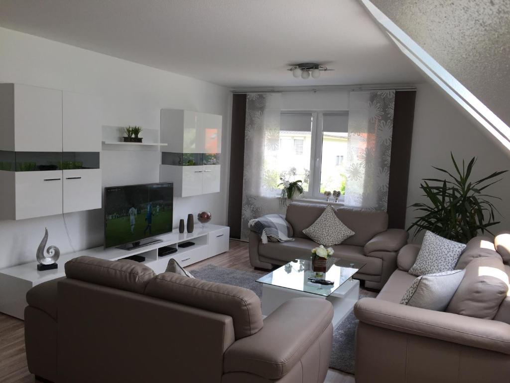 ein Wohnzimmer mit Sofas und einem TV in der Unterkunft Ferienwohnung Unikat Harz in Bad Harzburg