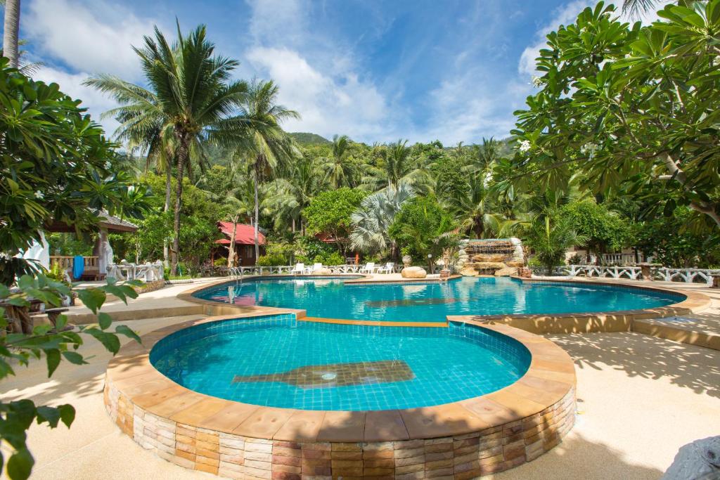 a pool at a resort with trees in the background at Bottle Beach 1 Resort in Bottle Beach