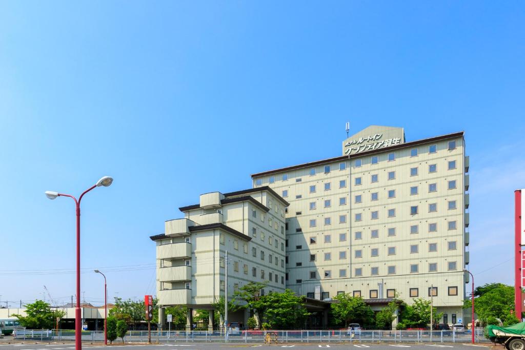 um edifício branco com uma placa em cima em Route Inn Grantia Hanyu Spa Resort em Hanyu