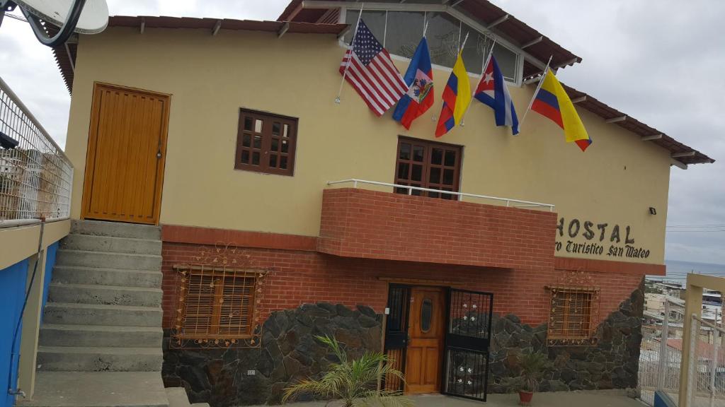 a building with flags on the side of it at Hostal Centro Turístico San Mateo in Manta
