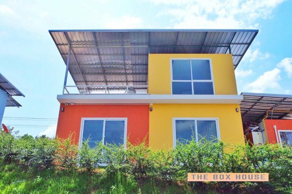 una casa amarilla y roja con techo en The Box House en Krabi