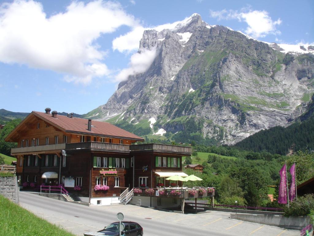 グリンデルワルトにあるホテル アルペンブリックの山を背景にした大きな建物