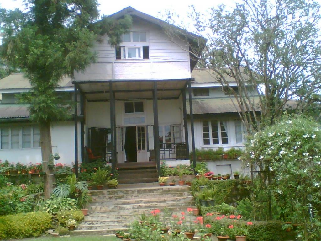 a white house with flowers in front of it at Razhu Pru in Kohīma