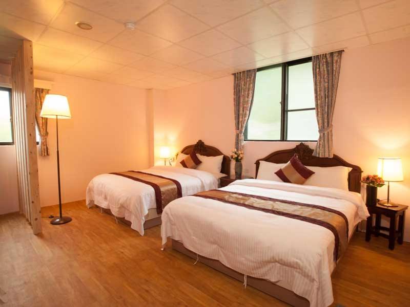 um quarto de hotel com duas camas e uma janela em Ideal Hot Spring Water Hotel em Jiaoxi