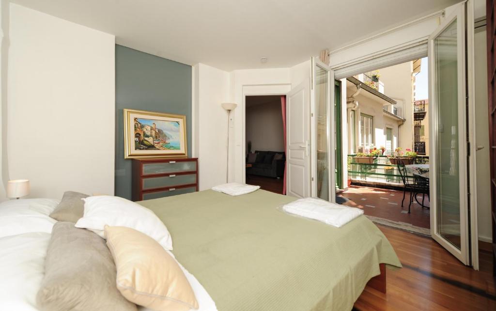 ニースにあるAppartamento La Terrasse Zen Five stars Holiday Houseのベッドルーム(大きな白いベッド1台、バルコニー付)