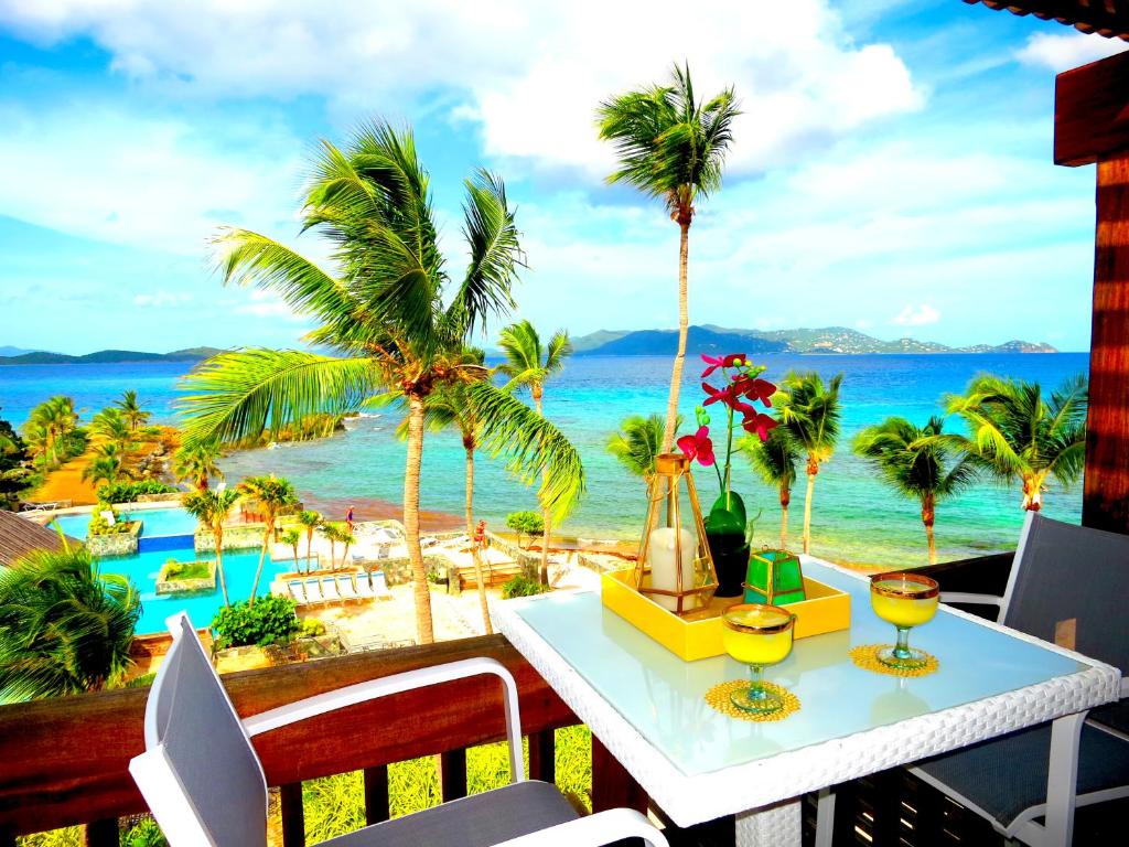 a table with a view of the beach and the ocean at Luxury Beachfront Duplex Villa on Sapphire Beach V in St Thomas