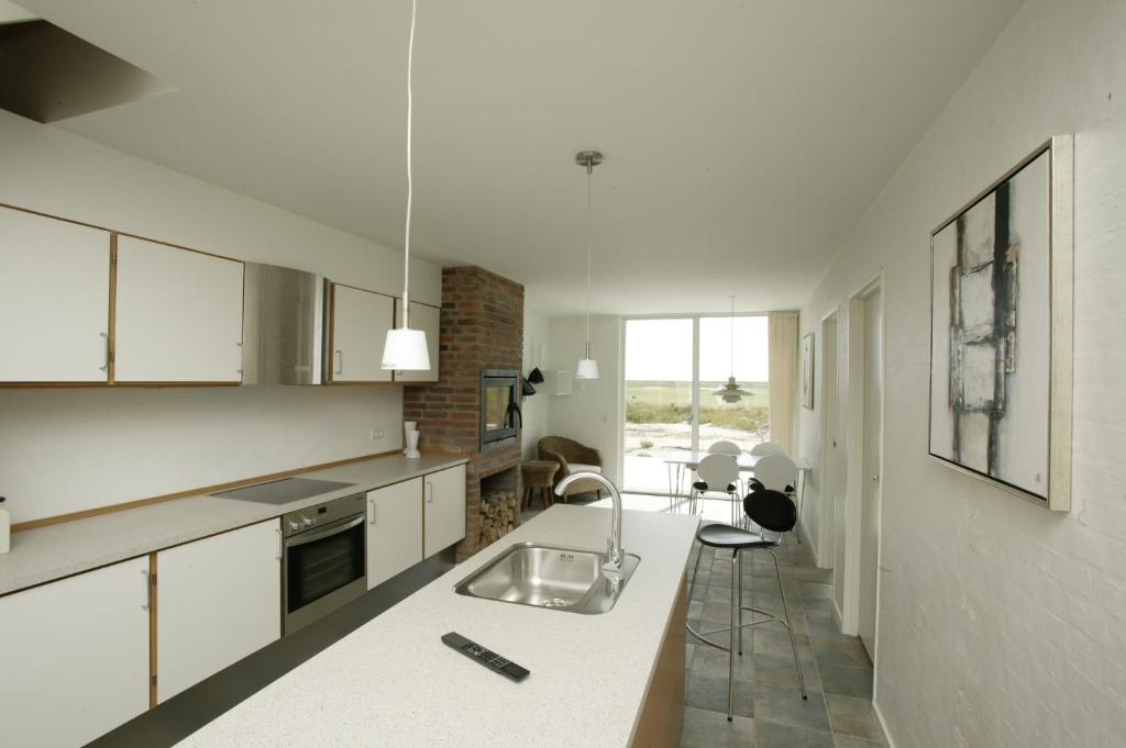 
a kitchen with a stove, sink, and refrigerator at Enjoy Resorts Rømø in Rømø Kirkeby
