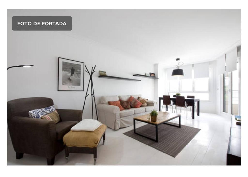 uma sala de estar com um sofá e uma mesa em White Cozy Flat in Donostia em San Sebastián