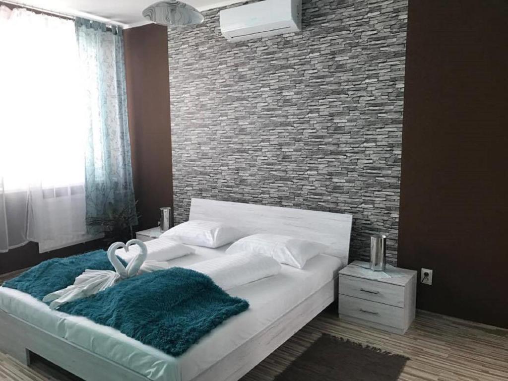 a bedroom with a large bed with a brick wall at Hotel Hubert Nové Zámky in Nové Zámky