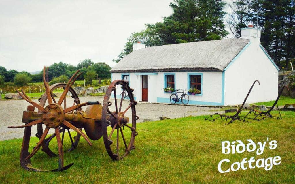 una estatua de un tractor delante de una casa en Biddys Cottage, en Culdaff