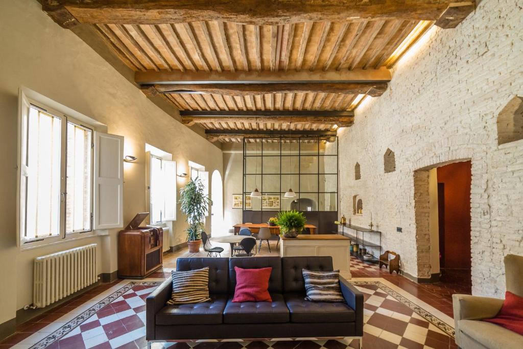 a living room with a black couch and a brick wall at Casatorre dei Leoni Dimora Storica in Siena