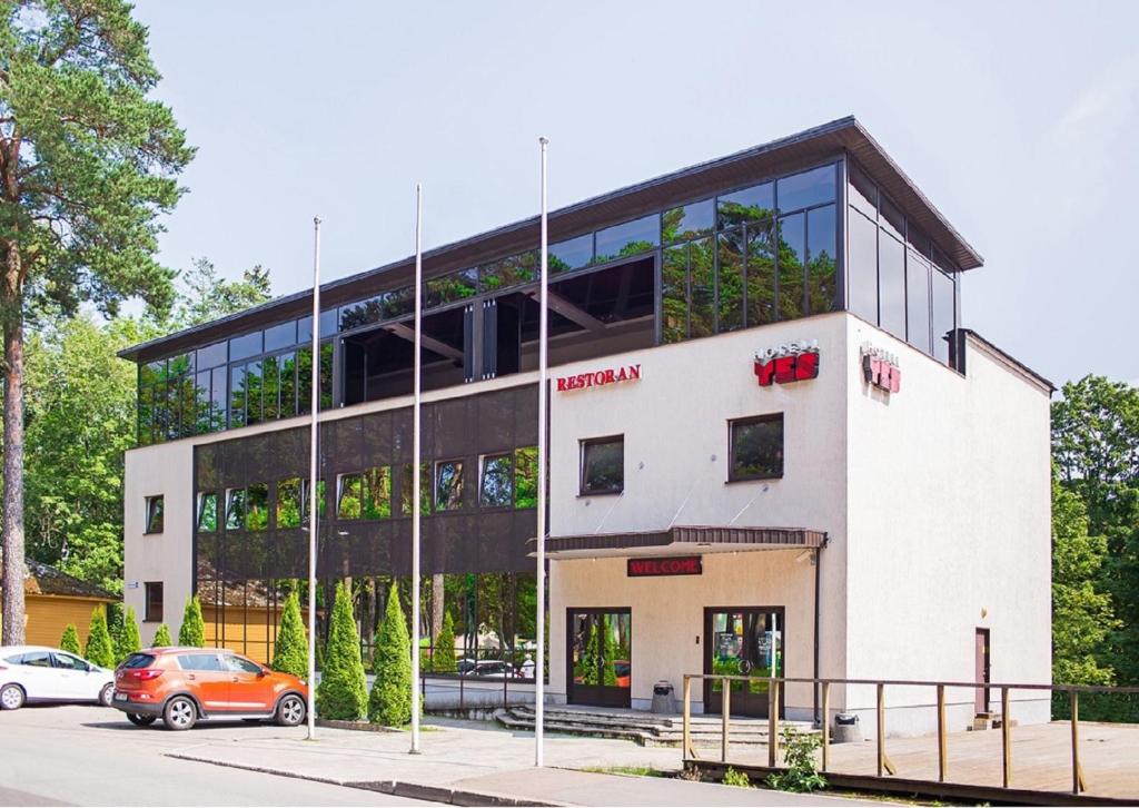 a building with a car parked in front of it at Hotel Yes in Narva-Jõesuu