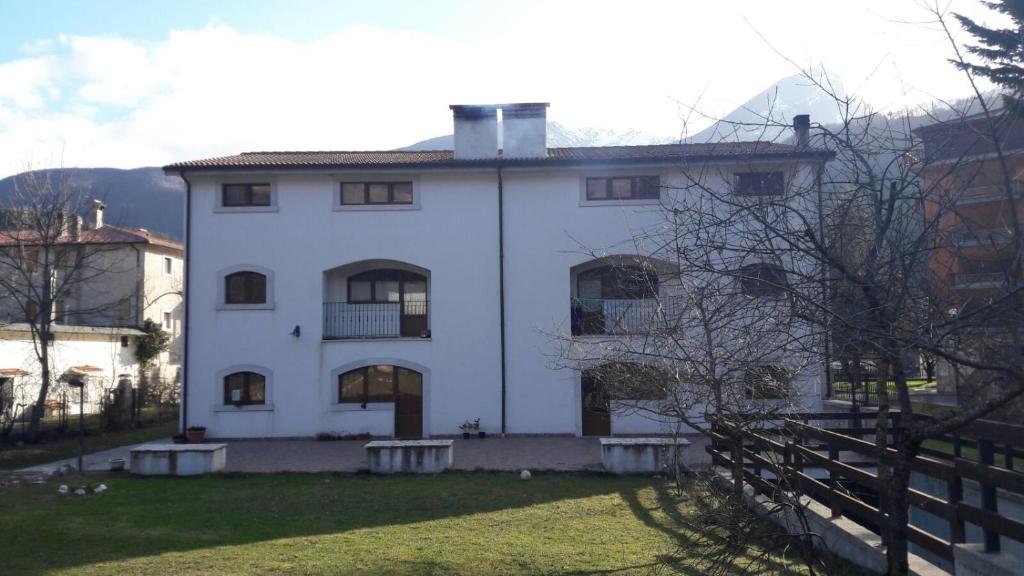 a white house with a fence in front of it at Affittacamere L'Airone in Villetta Barrea