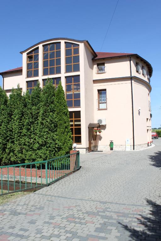 Biały budynek z płotem przed nim w obiekcie Hotel Oaza w mieście Prudnik