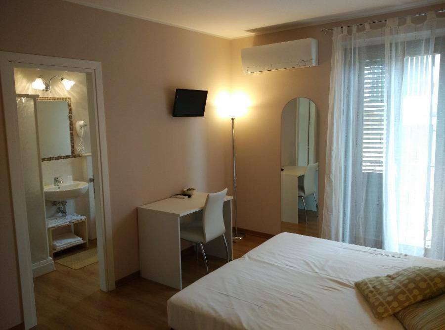 a bedroom with a bed and a desk and a sink at La marina in San Benedetto del Tronto