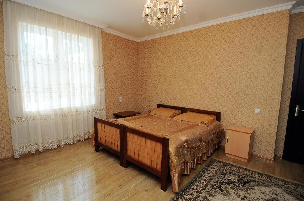 een slaapkamer met een bed en een kroonluchter bij Guest House Darejani in Koetaisi
