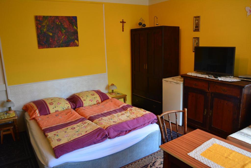 a bedroom with a bed and a tv and a table at Privat Henry in Liptovský Mikuláš