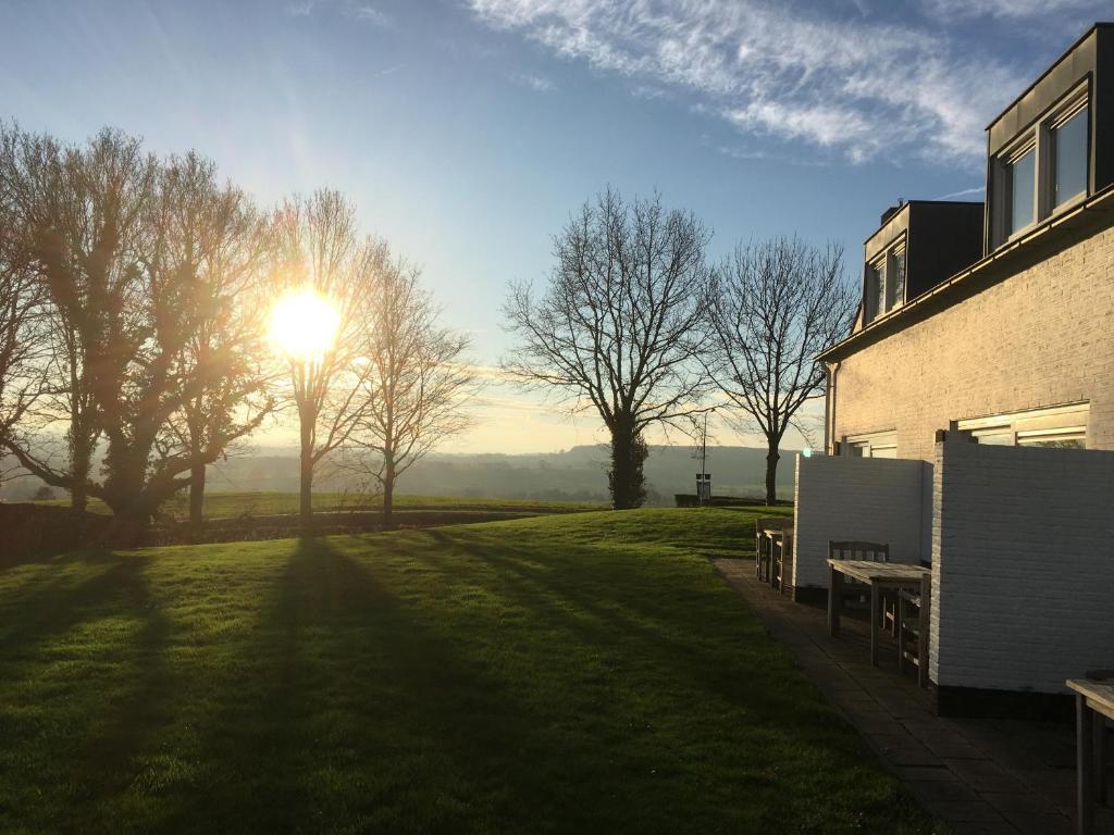 un sol brillando en un campo de césped junto a un edificio en Appartementen Ons Krijtland, en Epen