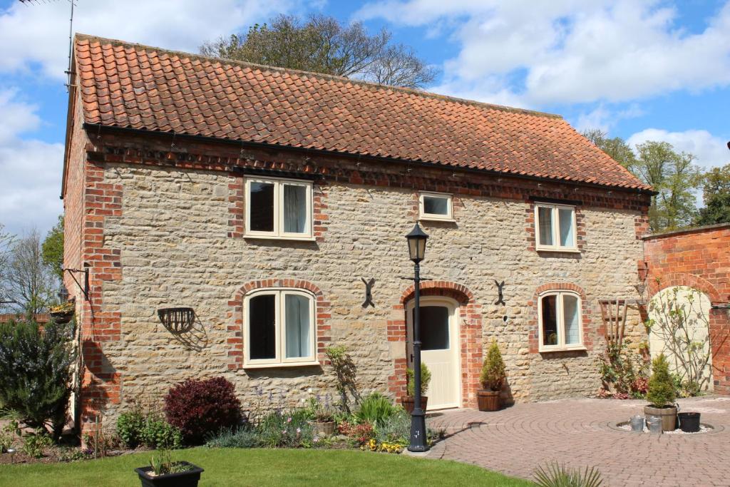 a stone house with a red roof at Church View Cottage, Ewerby in Sleaford