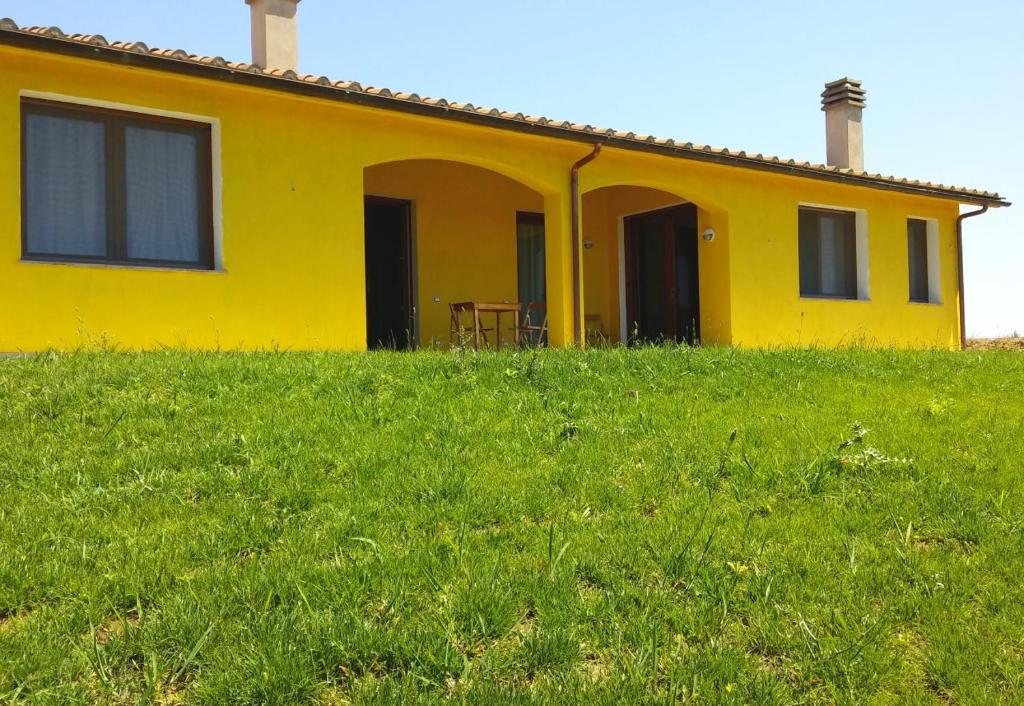 卡帕爾比奧的住宿－Il Chiosco Giallo，郁郁葱葱的绿色田野顶部的黄色房子