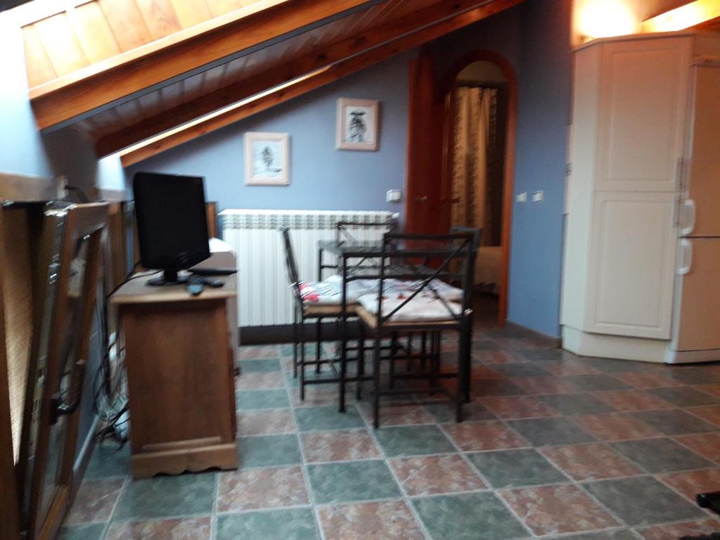 a living room with two chairs and a television at ORDINO 2 A in Rascafría